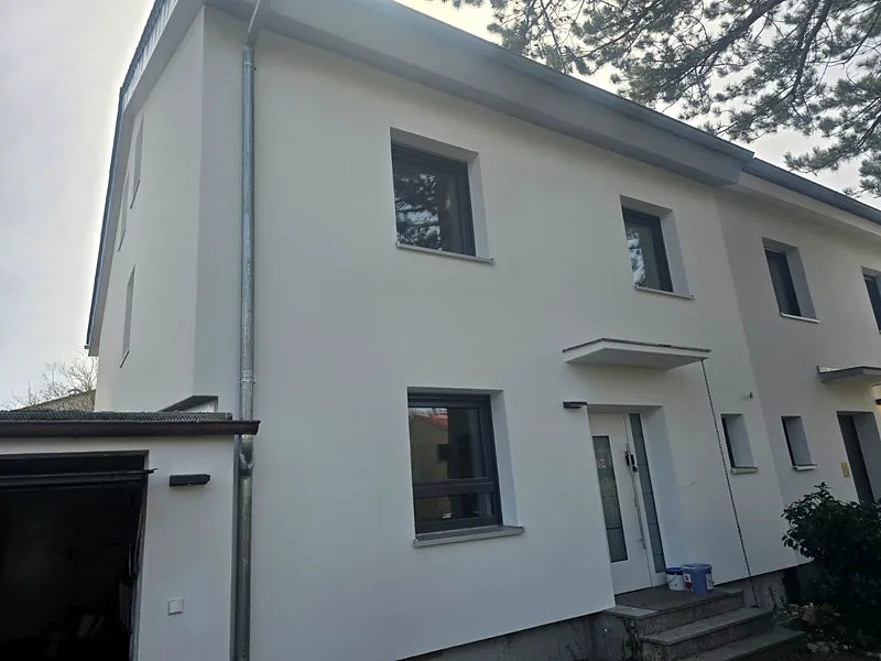 Fertig verputzte, weiße Fassade eines Einfamilienhauses