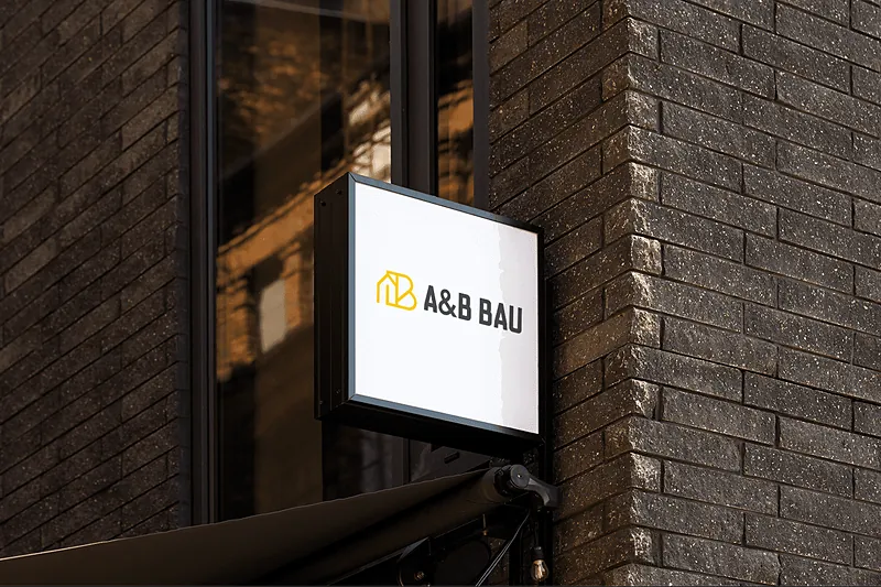 A&B Bau Schild an einer Backsteinfassade